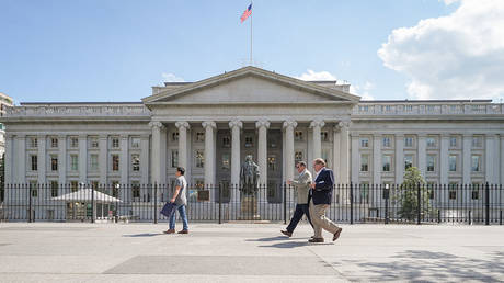 Pedestrians walk past the north entrance to the US Treasury Department headquarters building on April 30, 2025, in Washington, DC.