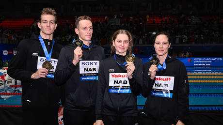Independent Athletes of Russia show the medals after competing in the swimming 4x100m Medley Relay Mixed Final during the 22nd World Aquatics Championships at the WAC Arena. Singapore.