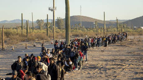 FILE PHOTO: Migrants line up after crossing the US-Mexico border.