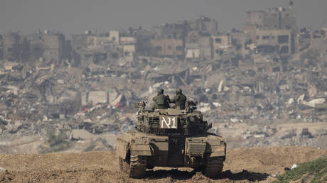 FILE PHOTO: Israeli soldiers stand on a tank near the border with the Gaza Strip.