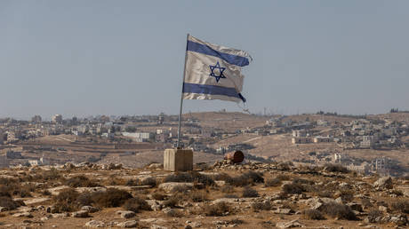 FILE PHOTO: An Israeli flag flies in the South Hebron Hills of the West Bank.