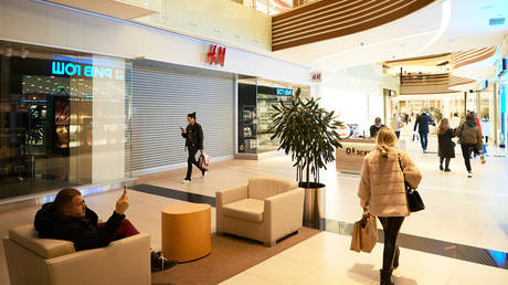 FILE PHOTO: Shoppers go past closed H&M store in Vegas shopping mall in Moscow, Russia.