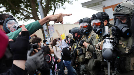 Federal agents and pro-immigration protesters on October 4, 2025 in Portland, Oregon.