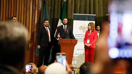 Syrian President Ahmed al-Sharaa speaks to voters at a polling station during parliamentary elections in Damascus, Syria, October 5, 2025.