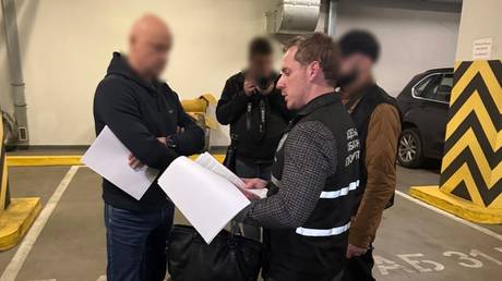 Police officers inform Gennady Trukhanov of the criminal investigation against him.