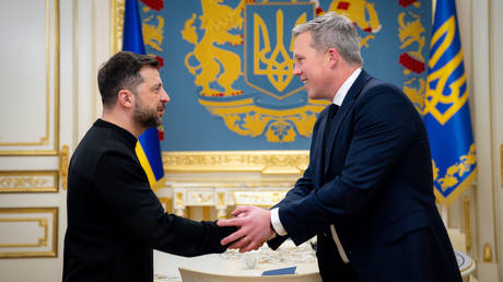 Ukraine’s Vladimir Zelensky shaking hands with US Secretary of the Army Daniel Driscoll.