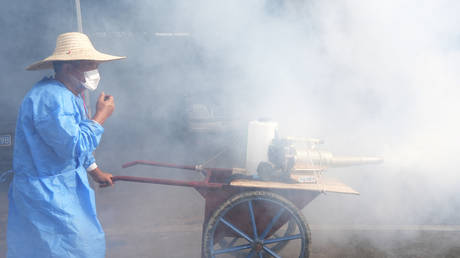 A worker sprays insecticide in Foshan, China, July 29, 2025.