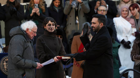 Sen. Bernie Sanders administers the oath of office to Mayor Zohran Mamdani as Rama Duwaji holds the Quran, January 1, 2026, in New York
